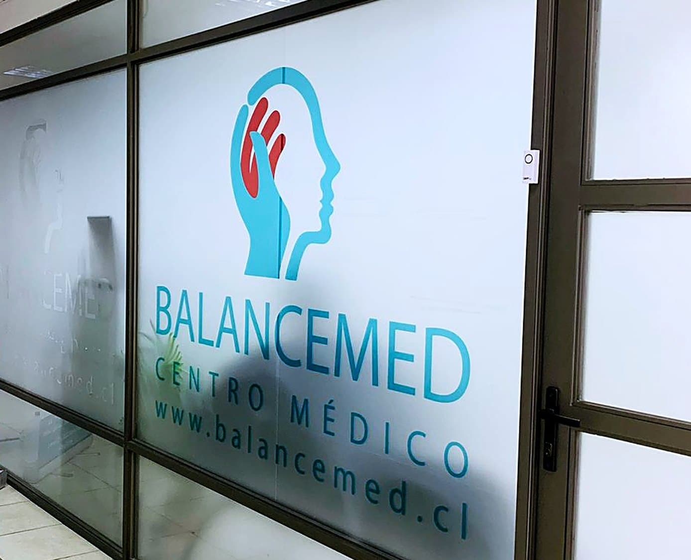 Entrada del centro médico BalanceMed, con el logotipo en el muro de vidrio